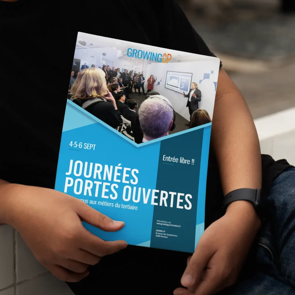 MOCKUP : Flyer des journées portes ouvertes organisée par l'organisme de formation GrowingUp entre les mains d'un homme